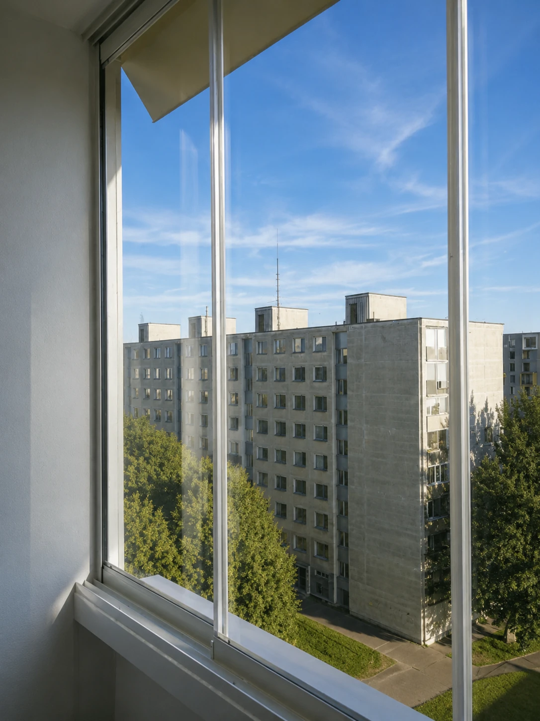 Výhľad cez zasklenú lodžiu na mesto